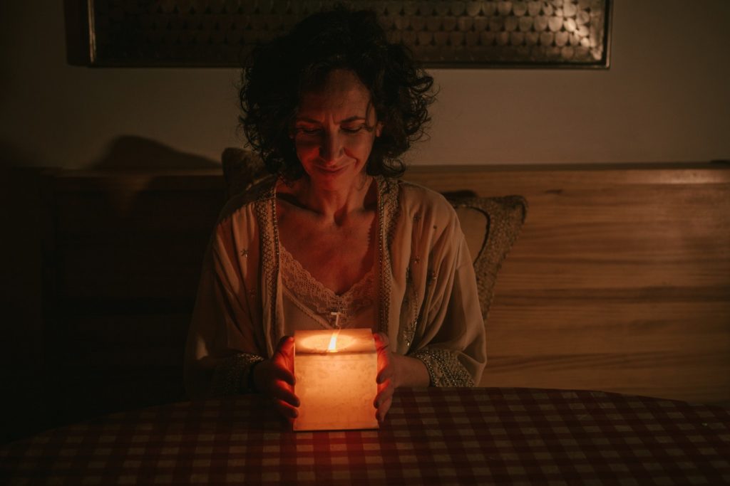 Ana Gil- Coach de Mindfulness y Astrología en León con una vela entre las manos